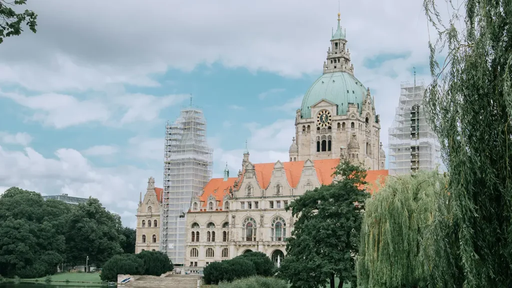 Das Neue Rathaus in Hannover bei Tageslicht mit Baugerüsten – Bildmotiv für regionale Verbundenheit und moderne Dienstleistungen rund um ‚Homepage erstellen lassen Hannover‘.