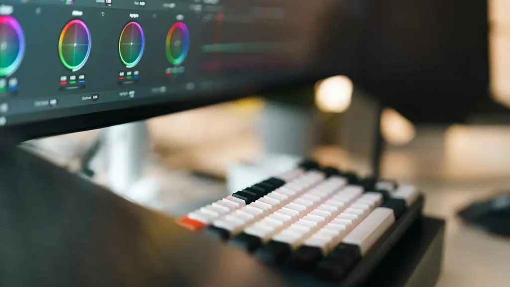 Nahaufnahme einer Tastatur vor einem Monitor mit Farb- und Analyse-Tools – Symbol für Webdesign und Suchmaschinenoptimierung