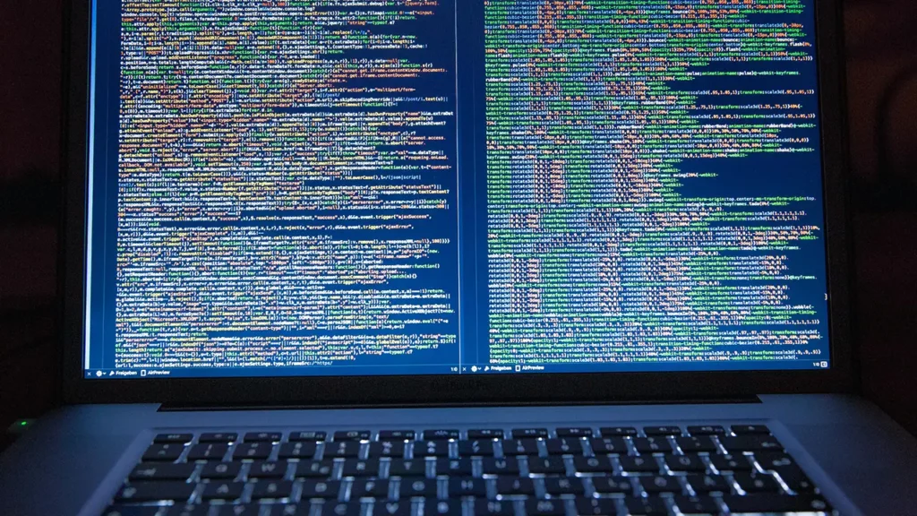 Laptop-Bildschirm mit umfangreichem Quellcode in einem Editor-Fenster, Symbol für Webentwicklung