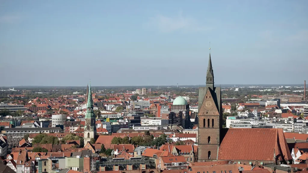 Panoramablick auf Hannover mit historischem Stadtkern und modernen Gebäuden, Sinnbild für die Verbindung von Tradition und Innovation.