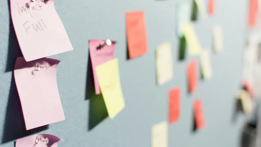 Bunte Post-its an einer Wand zeigen Content-Ideen und Aufgaben, die für die Planung einer Content-Marketing-Strategie im KMU genutzt werden.